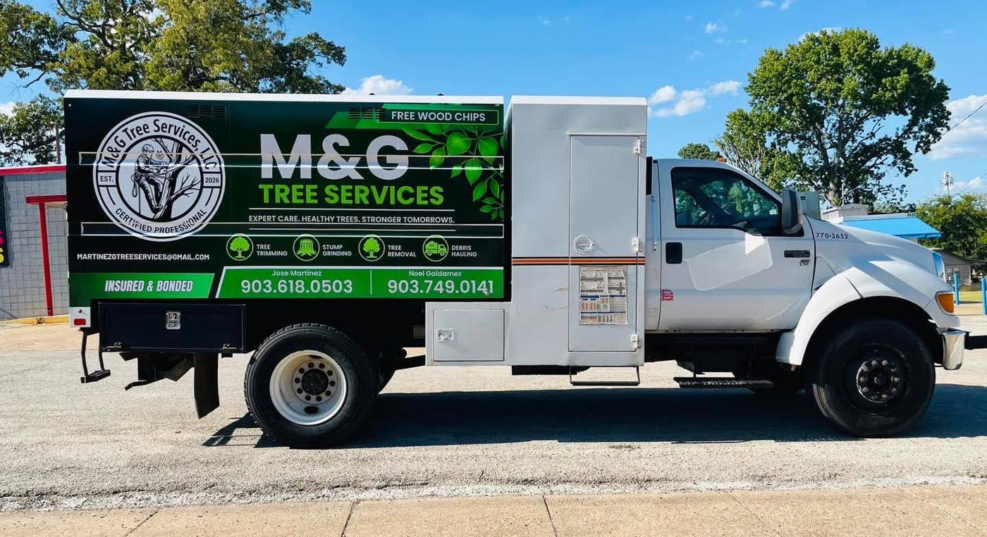The M&G Tree Services chip truck, green and white, parked on a street